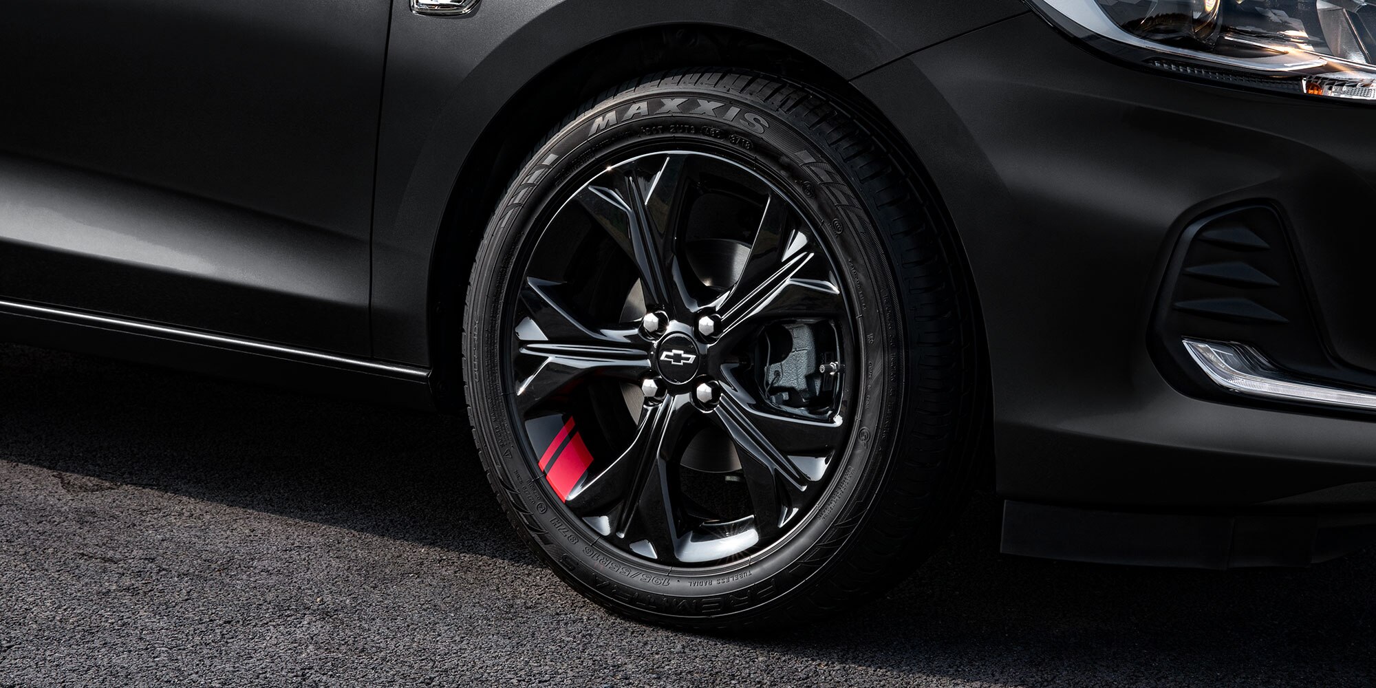 Chevrolet Onix 2025 versión Redline, sedán deportivo con detalles en rojo en sus rines de 16 pulgadas